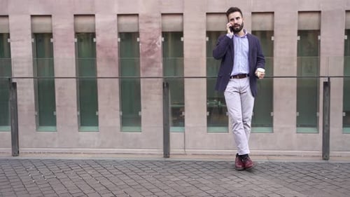 Young Middle East Businessman Talking on Phone in a Modern Corporate Business District