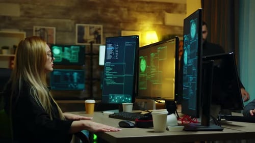 People Coding On Computers in a Dimly Lit Room