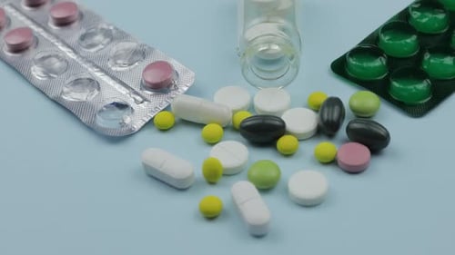 Assorted Pills and Capsules on Blue Surface