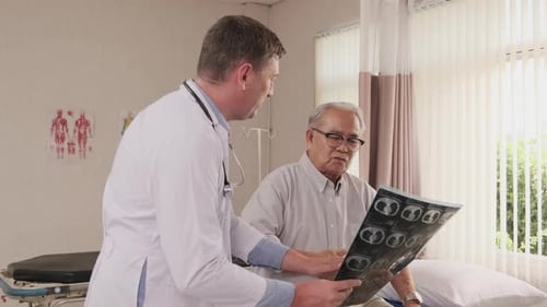 Doctor health checks elderly patient in bed of emergency room at hospital ward.