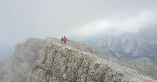 Aerial drone view of a man and woman couple hiking in the mountains