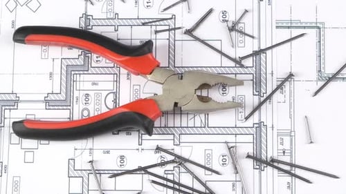 Gray and Red Pliers on Building Plan, Scheme Among Nails, Rotation