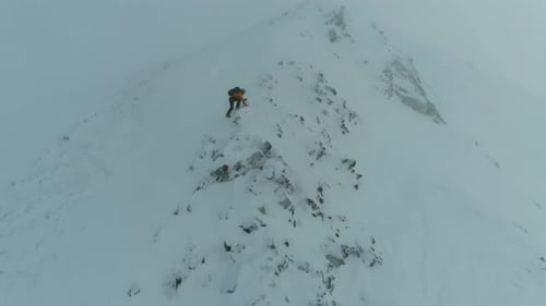 Mountain Climber Traversing a Snowy Rock Face