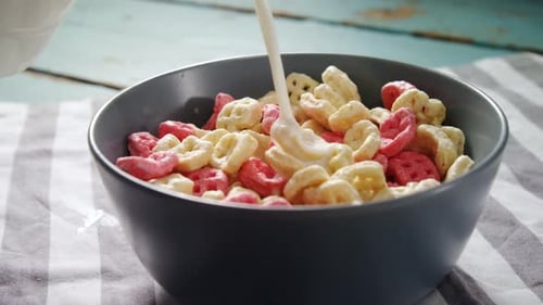 Pouring Milk Over a Colorful Bowl of Cereal