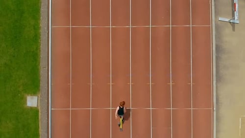 Woman Runner Preparing to Sprint on Racetrack