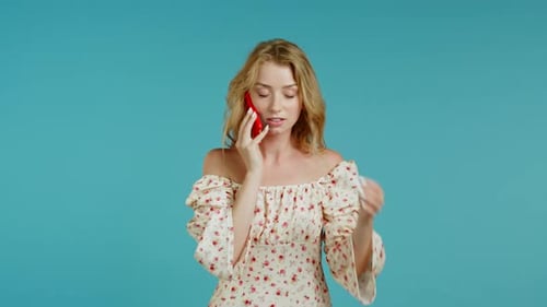 Woman in Floral Dress Talks on Cellphone