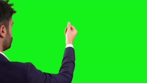 Businessman making money sign with his hand. Green background.