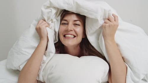 Mulher escondida debaixo do edredom