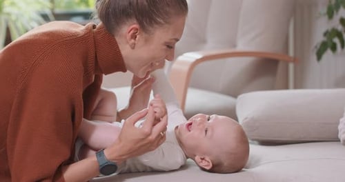 Close Up of the Baby Lying on Its Back on the Couch Smiling and Happy Uprising Hands and Feet