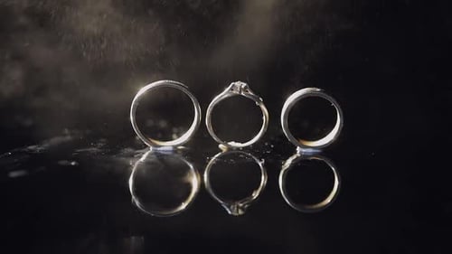 Wedding Rings with Water on Black Reflective Surface