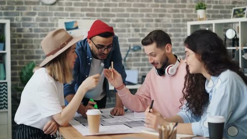 Interior Designers Sharing Ideas Looking at Building Plan Working in Office