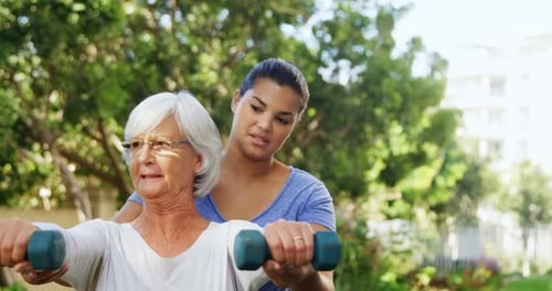 Senior Woman Exercising with Young Adult Supporter