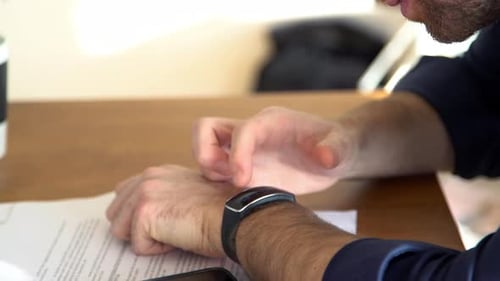 Man Checks Fitness Tracker on Smart Watch