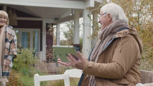 Senior Couple Using Tablet Outside in the Yard