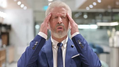 Stressed Adult Rubbing Temples Indoors