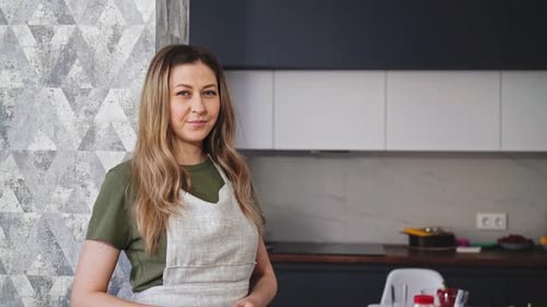 Woman Smiling Wearing Apron in Modern Kitchen