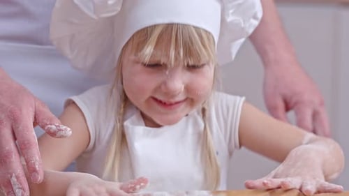 Delighted Child Baking Dough with Adult Assistance