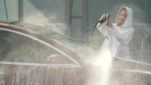 Young Woman is Washing the Car on a Selfservice Car Wash