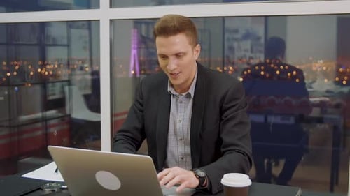 Surprised Business Man Watching Shocking News in Laptop Computer in Office