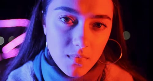 Stylish Young Woman Posing under Neon Lights