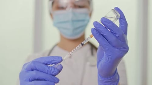 The Doctor Fills the Syringe With the Vaccine in Preparation for the Injection