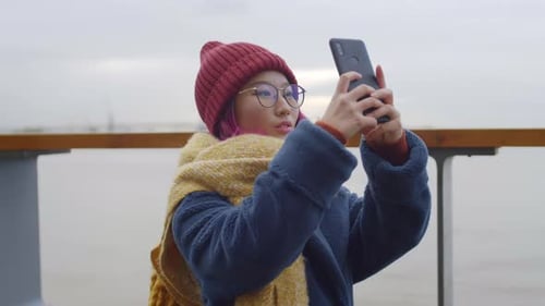 Young Woman Using Phone By Waterway