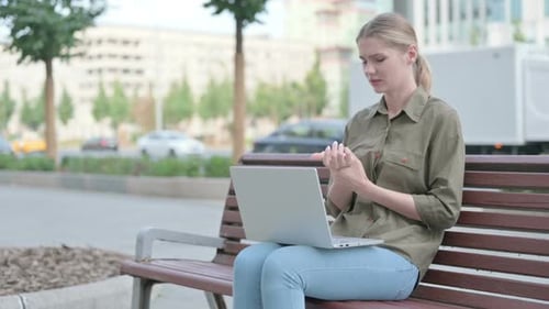 Woman Uses Laptop on Bench, Experiences Wrist Pain