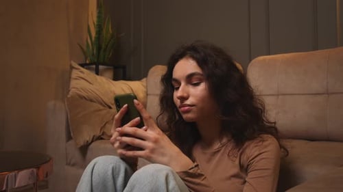Young Woman Using Smartphone Smiling at Home