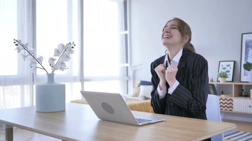 Woman Celebrating Success While Working on Laptop
