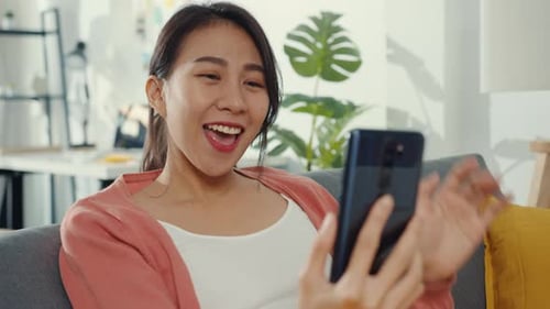 Woman Video Chats on Phone at Home