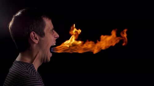 Young Adult Man Breathing Fire in Studio