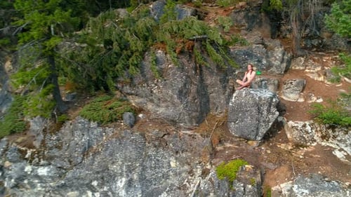 Woman performing yoga on top of a mountain 4k