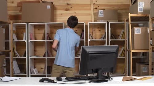 Caucasian Male Post Office Clerk Registering Mail on Computer