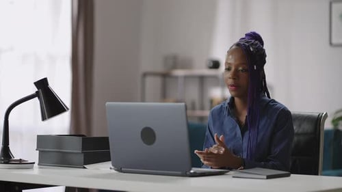 Young Adult Woman Talking to Laptop at Desk