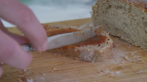 Spreading Jam on Bread Slice With Knife