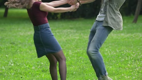 Cheerful Couple Spinning and Laughing in Green Park