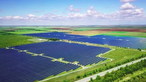 Photovoltaic Solar Panels on Green Field at Sunny Day. Aerial Landscape