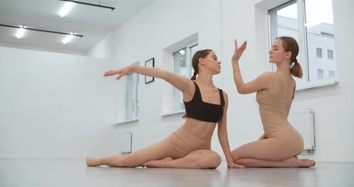 Two Young Dancers Are Rehearsing Their Perfomance in the White Bright Dance Hall Ballet Rehearsal