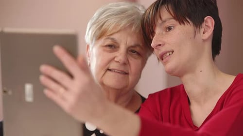Grandmother and Young Adult Looking at Tablet Together