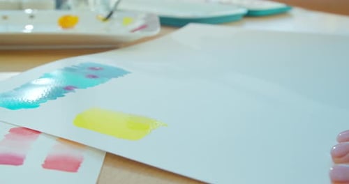 Hand with Brush Painting with Watercolor Abstract Stains.