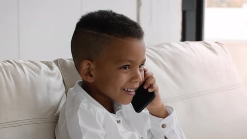 Young Boy Talking on Cell Phone on Couch