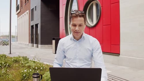 Junge und attraktive Freelancer, die im Freien arbeiten. Büroangestellter oder Geschäftsmann.