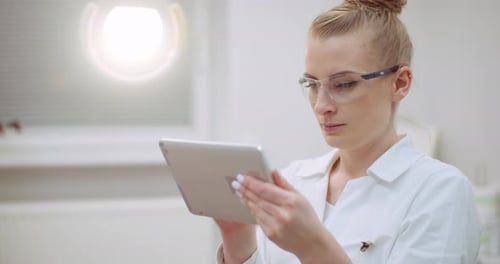 Female Doctor Using Digital Tablet at Dental Clinic