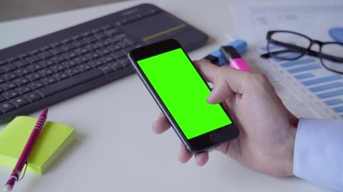 Businessman with Green Screen on Smartphone. Business, Deadline and Technology Concept - Businessman