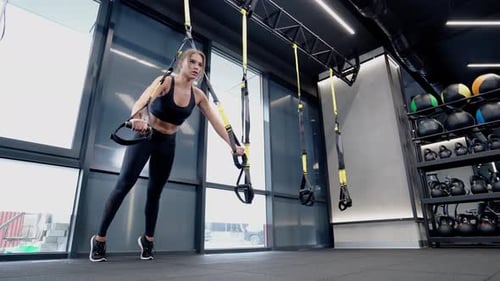 Attractive Woman Doing Exercise for Hands in Gym