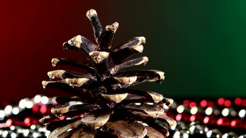Pine Cone for Christmas or New Year and Beads, Rotation, on Red and Green, Close Up