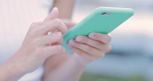 Woman's Hands Typing on Mobile Phone Touchscreen