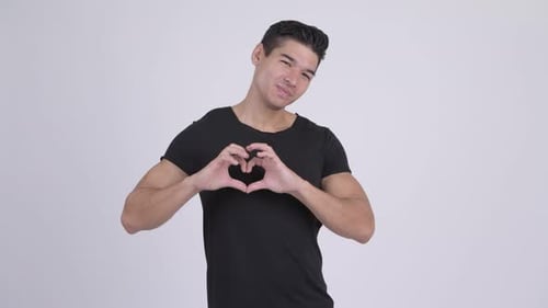 Man Smiles and Makes Heart Shape with Hands