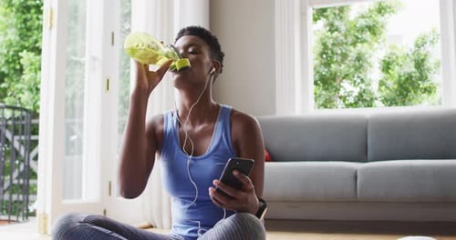 Woman Drinks Water After Exercise With Smart Phone