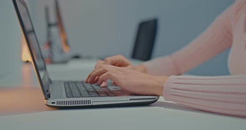 Typing on Gray Laptop in Office Setting